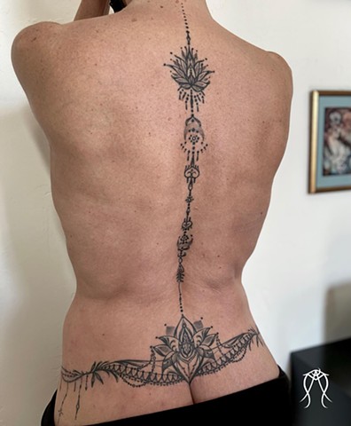 Intuitive Tattoo Art by Female New York Tattoo Artist Amanda Marie Of a ornamental spine tattoo with lotus and mandala design detail done in black and grey