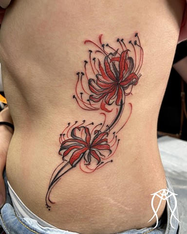 This is a red spider lily botanical floral tattoo done by female tattoo artist Amanda Marie witchery in her private tattoo studio ace of wands tattoo in central new York 