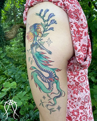 This is a mythological celestial siren dragon tattoo done in color by Amanda Marie female tattoo artist and tarot reader in her private studio in Ithaca New York Scipio center New York east coast tattoo it feature plant spirit art and magick 