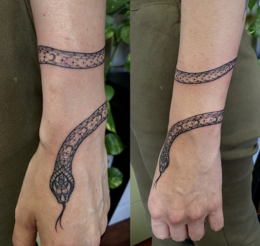 this is a tattoo of a mystic snake done by Amanda Marie tattoo artist and tarot reader in Los Angeles California it is delicate and ornate ornamental black and grey