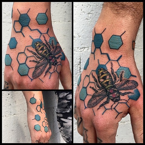 this is a geometric bee hand tattoo done by amanda marie at evermore tattoo in los angeles california 