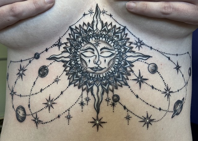 This is a celestial chandelier sternum tattoo including the sun and moon done in black and grey in a ornamental ornate style by Amanda Marie female tattoo artist in Los Angeles California at her private studio ace of wands