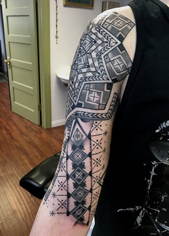 this is a tattoo of  a Ukrainian Easter Egg Inspired Half Sleeve done in a geometric ornamental style by Amanda Marie female tattoo artist and tarot reader in Los Angeles California 