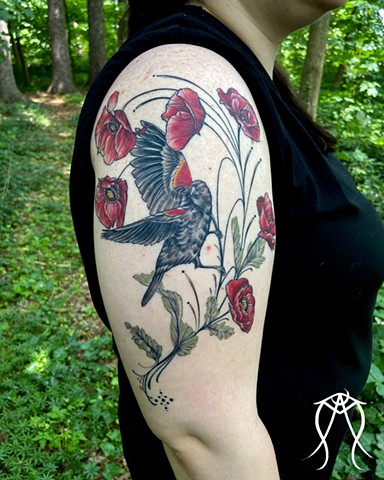 This is a nature inspired red winged bird and poppies poppy flower tattoo done in color by female tattoo artist and tarot reader Amanda Marie at her private tattoo studio in Scipio center New York near Ithaca east coast nature and floral tattoos 
