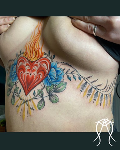 This is a sacred spiritual color ornamental sternum tattoo of a sacred flaming heart done by female tattoo artist and tarot reader Amanda Marie at her private tattoo studio in Scipio center New York Cayuga central New York 