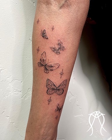 This is a tattoo of delicate ornamental butterflies done with a fine line in black and grey by female tattoo artist and tarot reader Amanda Marie at her private tattoo studio ace of wands tattoo in Scipio center New York central new York nature floral orn