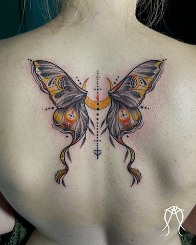 This is a magick tattoo of a lunar moth done in black and grey with pops of color by Amanda Marie witch artist tattoo artist in her private tattoo studio in upstate New York just outside of Ithaca it is a spiritual and sacred tattoo 