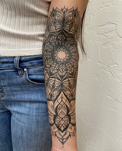 this is a tattoo of  butterfly inspired mandala rising from a lotus flower that is ornamental and ornate done in black and grey by Amanda Marie female tattoo artist tattooing in Los Angeles California in her private studio ace of wands in San Pedro 