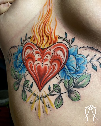 This is a sacred spiritual color ornamental sternum tattoo of a sacred flaming heart done by female tattoo artist and tarot reader Amanda Marie at her private tattoo studio in Scipio center New York Cayuga central New York
