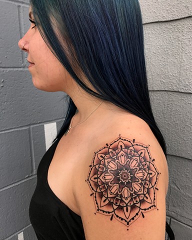 this is a shoulder cap mandala done in black and grey with a hint of red by amanda marie tattooer at ace of wands private intimate tattoo studio in san pedro los angeles california 