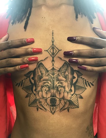 this is a wolf sternum tattoo that is also geometric and done in black and grey by amanda marie tattooer at ace of wands tattoo in san pedro los angeles california 