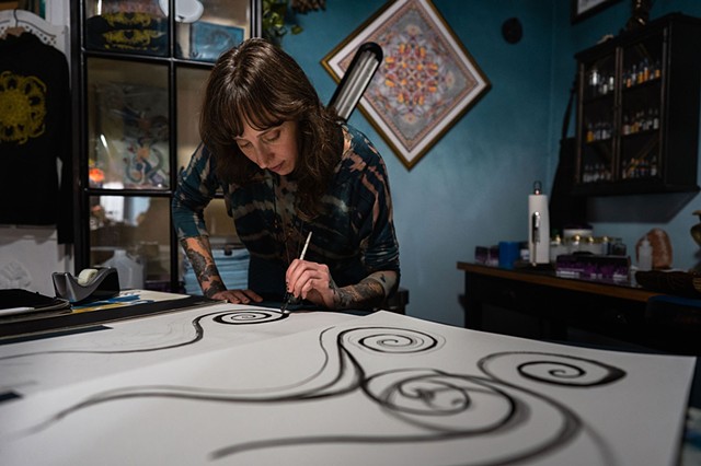 Amanda Marie female tattoo artist and tarot reader painting in her private tattoo and tarot studio in Scipio center New York 