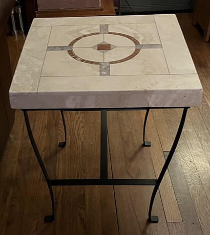 Inlaid marble table top with welded metal base.