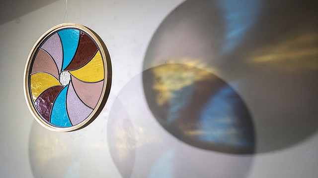 Natalie Hunter %Aperture 03, Light Unfolding (Shades of Dawn)% 2026 Glass, lead, zinc, hand shaped and curved oak, light. 20" round.  Produced with the generous support of the Canada Council for the Arts.