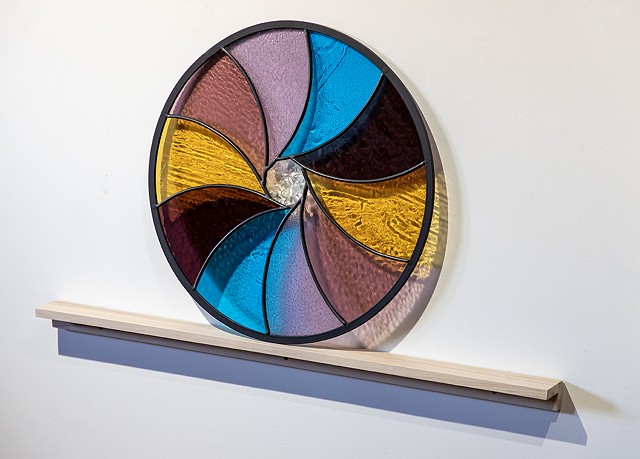 Natalie Hunter %Aperture 03, Light Unfolding (Shades of Dawn)% 2026 Glass, lead, zinc, birch, light. 20" round.  Produced with the generous support of the Canada Council for the Arts.