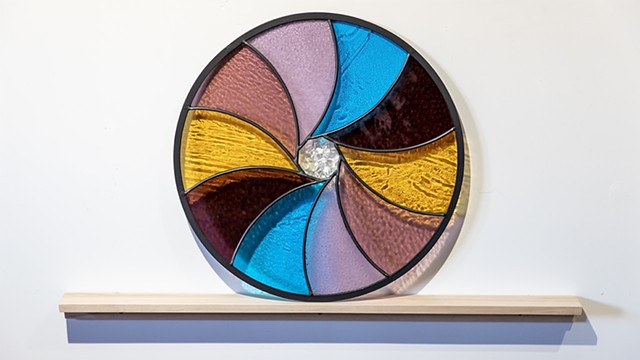 Natalie Hunter %Aperture 03, Light Unfolding (Shades of Dawn)% 2026 Glass, lead, zinc, birch, light. 20" round.  Produced with the generous support of the Canada Council for the Arts.