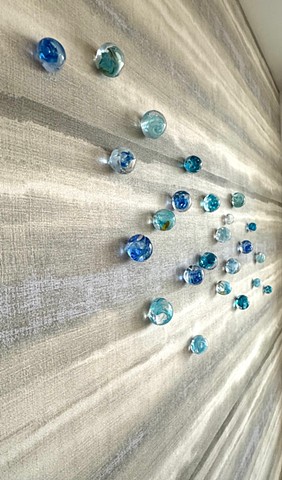 Blue glass cascades in organic pattern of a river or lake of blue, cobalt, turquoise art installation
