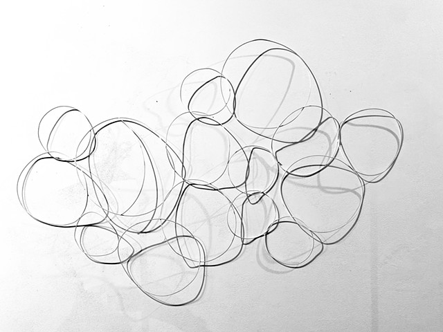 Modern white circular wall sculpture created with steel wire abstract circles
