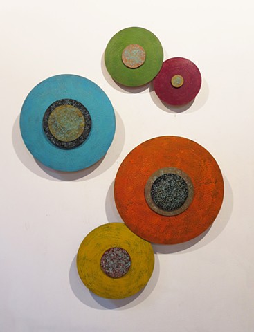 Abstract art installation wall sculpture of abstract disks painted with encaustic to create dimensional wall sculptural