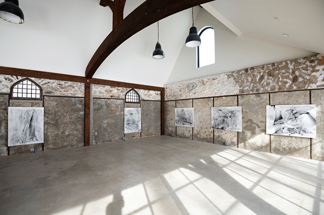 Installation view of three monochromatic drawings from Lacey McKinney's Contact Zone series displayed on historic stone wall at Foundation House artist residency in Greenwich, Connecticut. 