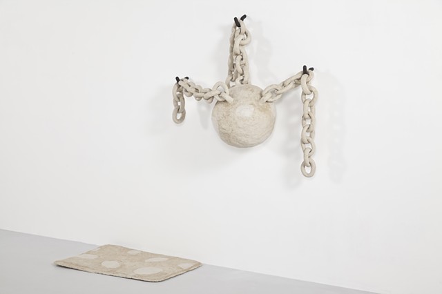 Clay sculpture by artist Paul March entitled Death Afterlife with Matching Doormat, resembling ball and chains suspended by mat