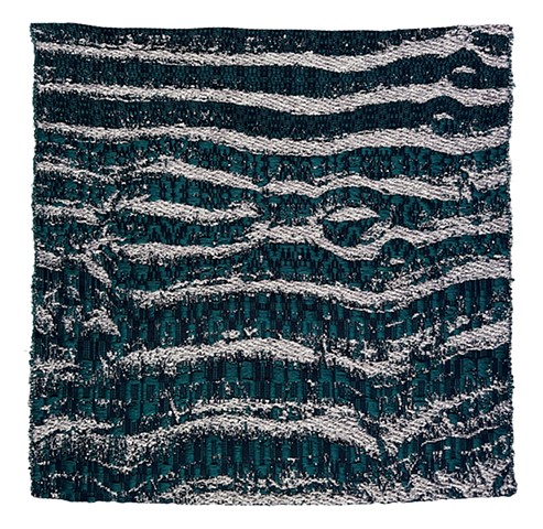 jacquard woven fabric depicting a washed out sandy beach with water left behind