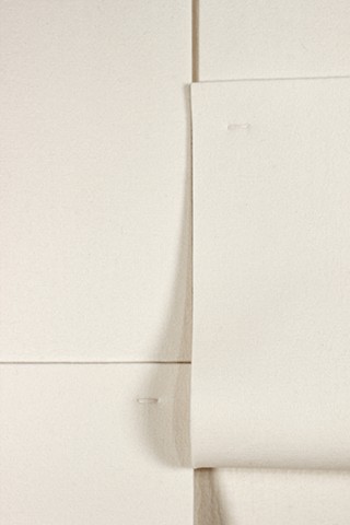 Off white vertical geometric composition in industrial felt with two tear drops created by folded felt straps