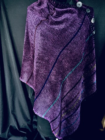 Handwoven poncho of rayon chenille, cotton and bamboo yarns.  Hand-embellished with crochet and buttons.