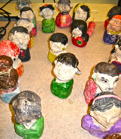 Group of 5th grade self-portrait miniature painted clay busts