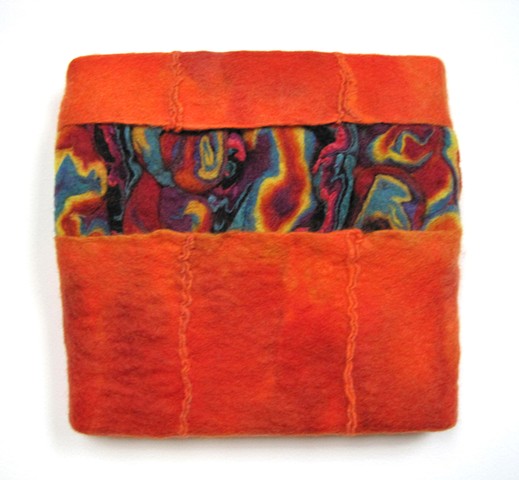 A handmade felt wall piece made of dyed, unspun wool and  yarns, by Sharron Parker.  Abstract, colorful, modular.