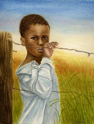 Young african boy standing at the fence.