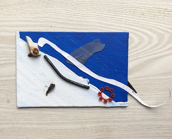 A small abstract fish sculpture using found objects, acrylic paint, and collage