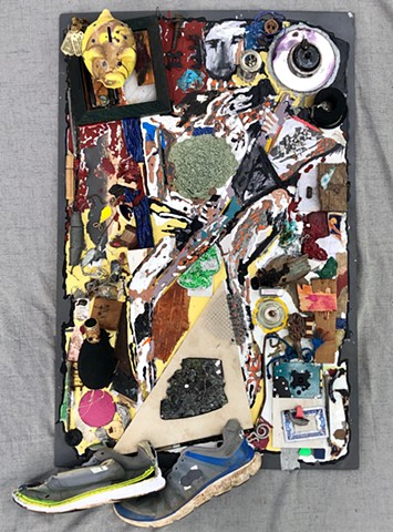 A mixed media figure piece of a man holding a guitar - lots of found objects