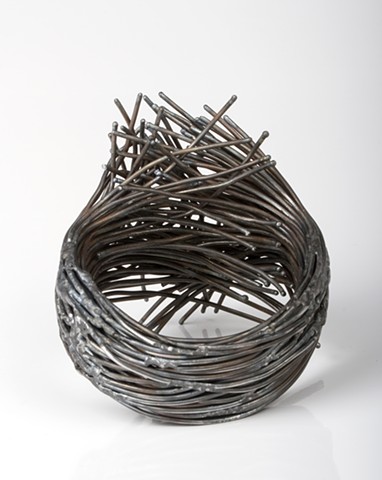 a one-of-a-kind sculptural bracelet that is composed of forged steel wire that has been welded together