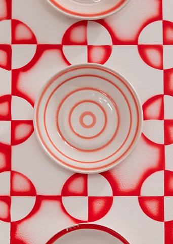 detail:  'Sculptures of diner plates--red: 01-09' on 'Pattern from 19th c red work quilt by unknown woman, applied to wall with stencil and airbrush like 1930s spritzdekor ceramics but also the interiors seen in photojournalism from the war in Ukraine...'
