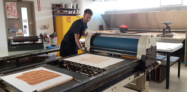 Myles Calvert printing a woodblock for me