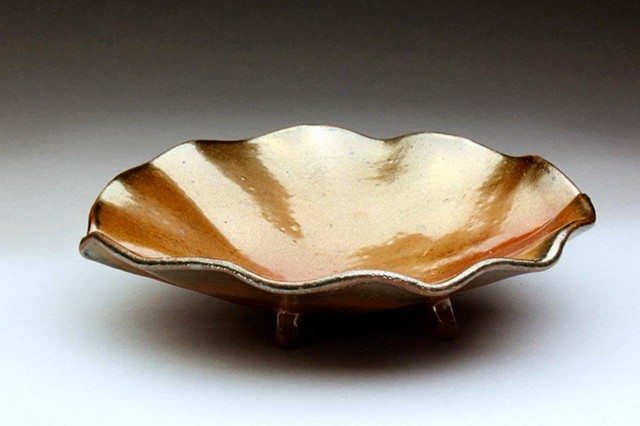 a wavy edged bowl with small feet