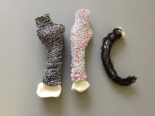 Three abstract bone-like sculptures with knitted coverings by Laura Evans