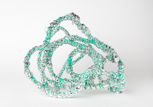 abstract basket made of mint plastic lacing and emergency blankets by Jose Santiago Perez