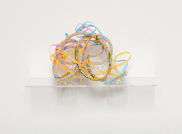 sculpture made with braided baby blue, pink, and tangerine plastic lacing and gold mylar emergency blankets by José Santiago Pérez
