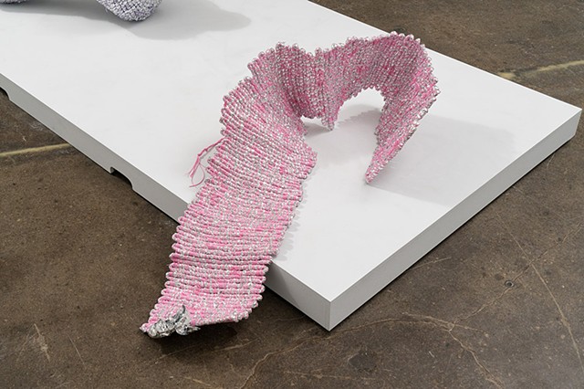coiled sculpture made with emergency blankets and pink plastic lacing by José Santiago Pérez
