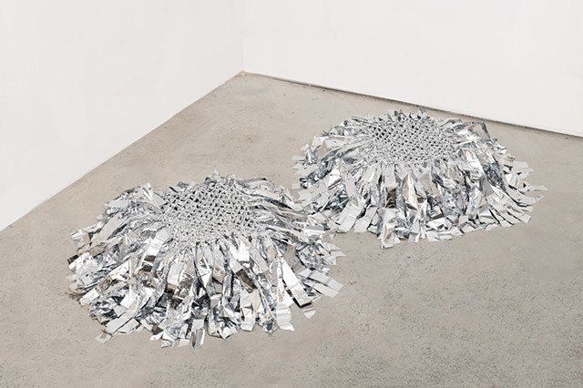 square floor sculptures made from hand netted nylon and knotted mylar emergency blankets by José Santiago Pérez