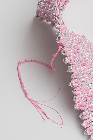 Detail of abstract coiled basket made with emergency blankets and pink plastic lacing by José Santiago Pérez