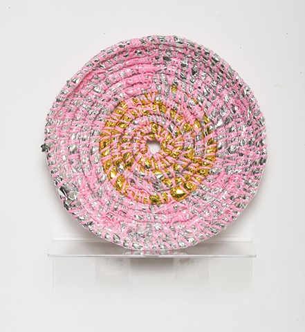 coiled sculpture in silver and gold mylar emergency blankets and pink plastic lacing by José Santiago Pérez