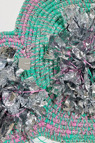 detail of wall based abstract coiled basket made with emergency blankets and mint and pink plastic lacing by José Santiago Pérez
