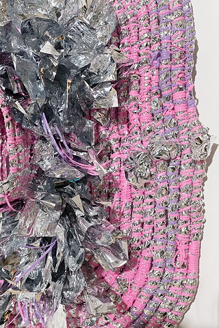 detal view of wall based abstract coiled basket made with emergency blankets and pink and lavender plastic lacing by José Santiago Pérez