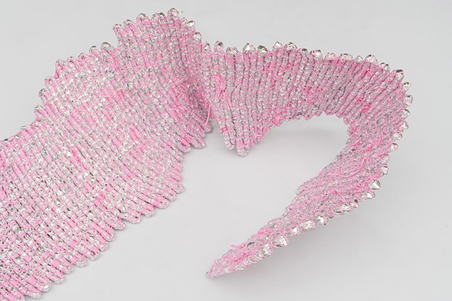coiled sculpture made with emergency blankets and pink plastic lacing by José Santiago Pérez