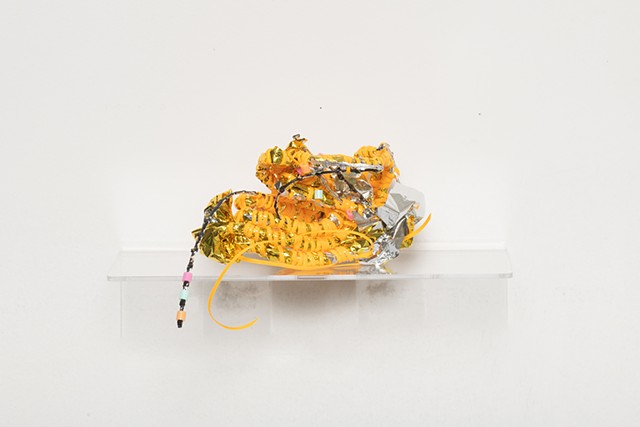 coiled sculpture in gold mylar emergency blankets, tangerine plastic lacing, plastic mesh, and mint, pink, and tangerine plastic beads by José Santiago Pérez