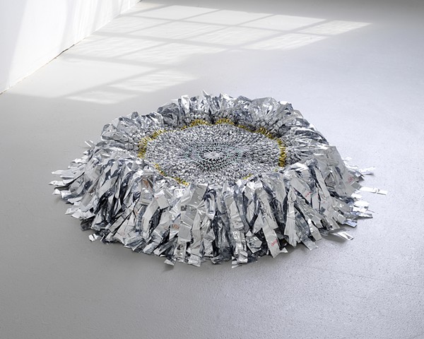 hand netted floor sculpture made with nylon, perler beads, and mylar strips by José Santiago Pérez rests on the gallery floor