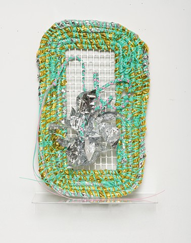coiled sculpture in gold and silver mylar emergency blankets, mint and lavender plastic lacing, plastic mesh, and silver leaf by José Santiago Pérez